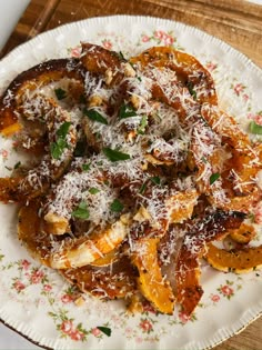 a white plate topped with pasta covered in sauce and parmesan cheese on top