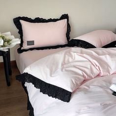 a bed with pink sheets and black ruffles