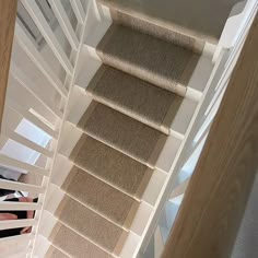 there is a woman walking down the stairs in this house with her feet on the carpet