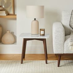 a table with a candle on it next to a chair