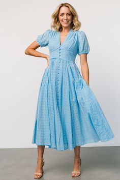 Baltic Born exclusive style Versatile vintage inspired dress for every occasion Lightweight woven eyelet material Classic sky blue color Narrow deep v-neckline Gathered bust and shoulder seam Upward-v paneled bodice with center-back smocking Delicate ruffled detail around panel. Functional domed buttons down front of dress Puff sleeve with elastic cuff Midi-length skirt A-line skirt with vertical seaming Skirt lined to the knee, fully lined bodice Self: 97% Cotton, 3% Polyester, Lining: 100% Cotton Trina is 5'6, cup size 32D, size 2 and is wearing size S Chic V-neck Eyelet Dress, Fitted V-neck Eyelet Dress, Chic Eyelet V-neck Dress, Fitted Eyelet Midi Dress For Daywear, Blue Midi-length V-neck Dress For Spring, Chic Fitted Eyelet Midi Dress, Fitted Eyelet Dress, Midi Length, Fitted Eyelet Dress Midi Length, Fitted Eyelet Midi Dress