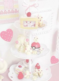 a three tiered cake stand with cupcakes, cakes and other items on it