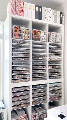 a white bookcase filled with lots of cds