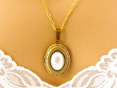 "Gold Plated Brass Locket Necklace: Carry photos of loved ones close to your heart with this Victorian-style gold plated brass locket embellished with a faux pearlcabochon. The working locket can hold 2 photos. I can make it with a gold plated chain in a length of your choice. Pendant Height: 1.6 inches Length - choose from 16 to 36 inches I can also make this with a silver plated locket, or with a faceted Bermuda Blue acrylic cabochon, as shown in the last photo, with either a silver plated or Adjustable Vintage Charm Jewelry For Wedding, Adjustable Vintage Charm Wedding Jewelry, Elegant Gold Locket Necklace For Wedding Gift, Oval Vintage Charm Locket Necklace For Wedding, Wedding Vintage Charm Oval Locket Necklace, Vintage Adjustable Locket Necklace For Wedding, Classic Locket Necklace For Wedding, Classic Locket Jewelry For Wedding, Classic Wedding Locket Jewelry