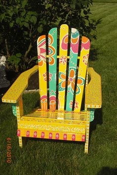 a colorful wooden chair sitting in the grass