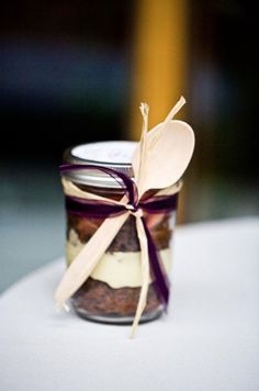 a jar filled with food sitting on top of a white table covered in purple ribbon