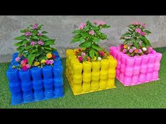 three plastic bottles are stacked on top of each other with flowers growing out of them