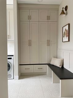 an empty laundry room with cabinets and a washer