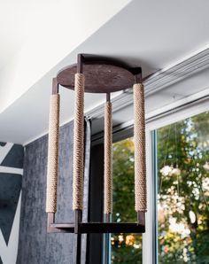 a cat tree hanging from the ceiling next to a window