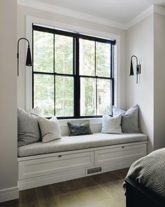 a white window seat with pillows on it