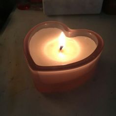 a heart shaped candle sitting on top of a table