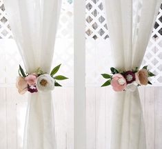 two white curtains with flowers on them in front of a window