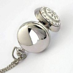 Very pretty white flower vintage style mini pocket watch necklace on a 30 inch chain. Case is high polished and mirrored. Back can be engraved for a personalized gift. Absolutely unique and lovely jewelry piece. Occasion: Great for Birthdays, holidays, any occasion gift. Size: The pocket watch is 30mm x 30mm Material: Alloy Bezel: High Quality Stainless Steel weight: 35 grams Order yours now or get it as a gift for a loved one!Operating Instructions: The watch opens by pressing down on the crown Vintage Silver Stainless Steel Pocket Watch, Elegant White Pocket Watch For Formal Occasions, Elegant White Pocket Watch For Formal Events, Classic White Pocket Watch As Gift, Silver Stainless Steel Pocket Watch As Gift, Vintage Silver Pocket Watch For Wedding, Elegant Stainless Steel Pocket Watch, Silver Vintage Pocket Watch, Silver Engraved Pocket Watch As Gift