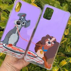 the lady and the tramp phone case is being held by someone's hand