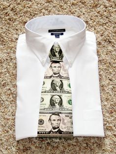 a dollar bill tie on top of a white dress shirt with money printed on it