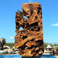 a large piece of wood sitting on top of a blue table next to some rocks