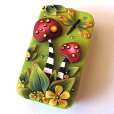 a cell phone case with mushrooms and flowers on the front, sitting on a white surface