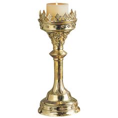 a golden candle holder with a white candle