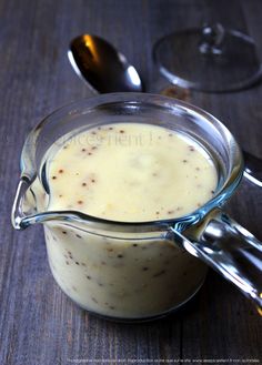 a glass pitcher filled with liquid sitting on top of a table next to spoons