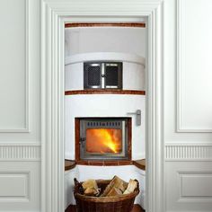 an open door leading to a fireplace in a room with white walls and wood flooring