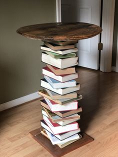 a stack of books sitting on top of a wooden table in front of a doorway