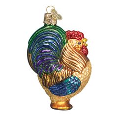 a glass ornament with a colorful rooster on it's head and tail