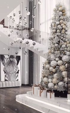 a decorated christmas tree sitting in the middle of a living room next to a staircase