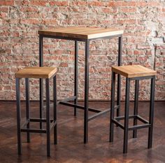 three stools and a table in front of a brick wall