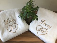 two white towels with embroidered hearts on them