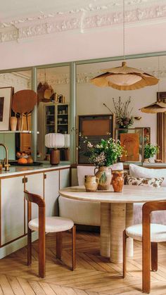 a dining room table and chairs in front of a mirror