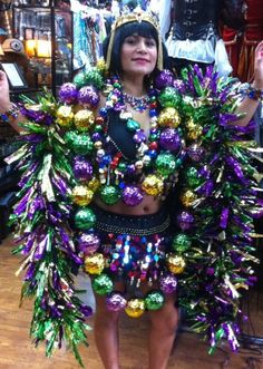 a woman dressed in a costume made out of tinsels and other decorations is posing for the camera