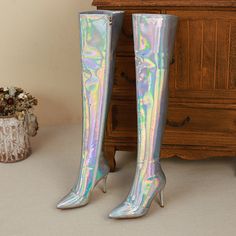 These holographic thigh high boots are sure to turn heads! They have a pointed toe and stiletto heels. and they zip up the back for a snug fit. They're also lined with plush fabric for a comfortable wear.Plus. they come in the most eye-catching silver hue. Whether you're hitting the club or just strutting your stuff around town. these boots are sure to get you noticed. So add them to your wardrobe and get ready to make a statement! Upper: Microfiber Lining: Short Plush Outsole: Rubber Toe: Point Party Metallic Fitted Boots, Metallic Fitted Heeled Boots With Pointed Toe, Metallic Fitted Boots For Night Out, Fitted Metallic Boots For Night Out, Fitted Metallic Winter Boots, Holographic Boots, Boots With Heels, Holographic Heels, Silver Holographic