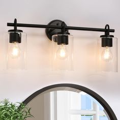 three light bathroom vanity fixture with clear glass jars on the front and back lights in black finish