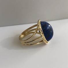 Lapis lazuli - richly blue and in excellent shape. This massive lapis is held in a beautiful vintage ring crafted in 18K yellow gold with beautiful braided bezel detail. The shank splits in three different bands tapering down to a single band at the bottom of 4.30mm This ring is currently a size 8.5 but can be sized down upon request. With any pre-owned/Vintage/Antique items, it is common to have some wear, As we inspect each piece of our jewelry, we make sure the wear and tear is acceptable wit Blue Domed Jewelry With Polished Finish, Elegant Blue Oval Cabochon Signet Ring, Blue Domed Gemstone Ring, Blue Cabochon Sapphire Ring In 14k Gold, Blue Cabochon Dome Ring, Yellow Gold Lapis Lazuli Cabochon Jewelry, Fine Jewelry Blue Cabochon Sapphire Ring, Formal Lapis Lazuli Gemstone Ring, Blue Cabochon Sapphire Ring In Fine Jewelry Style