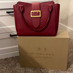 Cherry Red Burberry Handbag. Still In Excellent Condition. No Stains Or Tears Comes With Dust Bag And Box Red Shoulder Bag With Dust Bag, Red Shoulder Box Bag With Dust Bag, Designer Red Satchel Box Bag, Luxury Burgundy Shoulder Bag With Branded Hardware, Luxury Red Box Bag With Dust Bag, Designer Burgundy Shopping Bag, Designer Burgundy Bag For Shopping, Luxury Red Shoulder Box Bag, Luxury Red Box Bag With Detachable Strap