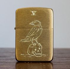 a gold lighter with a bird on it