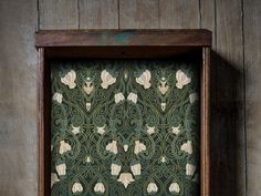 a wooden frame with an ornate pattern on it in front of a wood paneled wall