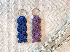 two crocheted keychains sitting next to each other on a white blanket