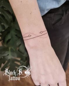 a woman's hand with a small tattoo on her left wrist and an arrow in the middle