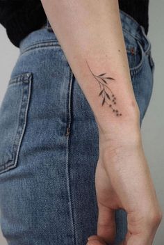 a woman's arm with a small flower tattoo on the left side of her wrist