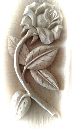 a wooden carving of a rose with leaves