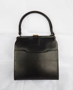 Vintage Black Handbag, Elegant Black Purse 1960's Classic Frame Bag Top Clasp, Mid Century Fashion  ♥ Beautiful true vintage c. 1960's handbag made of black faux leather with a beige vinyl interior. It has a doubled carrying handle and a brass top closure. One main compartment with interior zippered wall pocked and one exterior frontal slip pocket. This vintage purse is in a good condition: very clean, stain free interior, both the clasp and the interior zipper work great, there are surface scuf Vintage Black Shoulder Bag With Hasp Closure, Vintage Black Square Shoulder Bag, Vintage Rectangular Bags For Vintage Events, Vintage Rectangular Bags For Events, Vintage Box Shoulder Bag With Top Carry Handle, Vintage Box Bag With Detachable Handle For Evening, Vintage Evening Box Bag With Detachable Handle, Vintage Square Bags For Formal Occasions, Vintage Square Box Bag