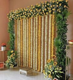 an arrangement of yellow flowers and greenery on the side of a wall in a room