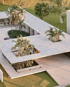 an aerial view of a modern house surrounded by palm trees