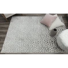 an animal print rug with white and pink pillows