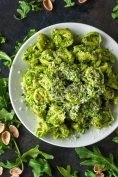 a white plate topped with broccoli covered in pesto