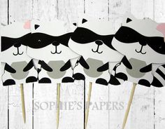 four black and white panda bear cupcake toppers on sticks with pink bows in the middle