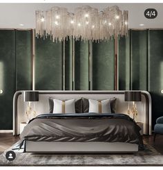 a modern bedroom with green walls and chandelier hanging from the ceiling, along with an upholstered bed