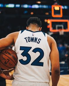 a man holding a basketball in his right hand and wearing a jersey with the number 32 on it