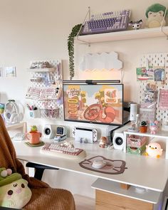 a desk with a computer monitor, keyboard and other items on it in a room